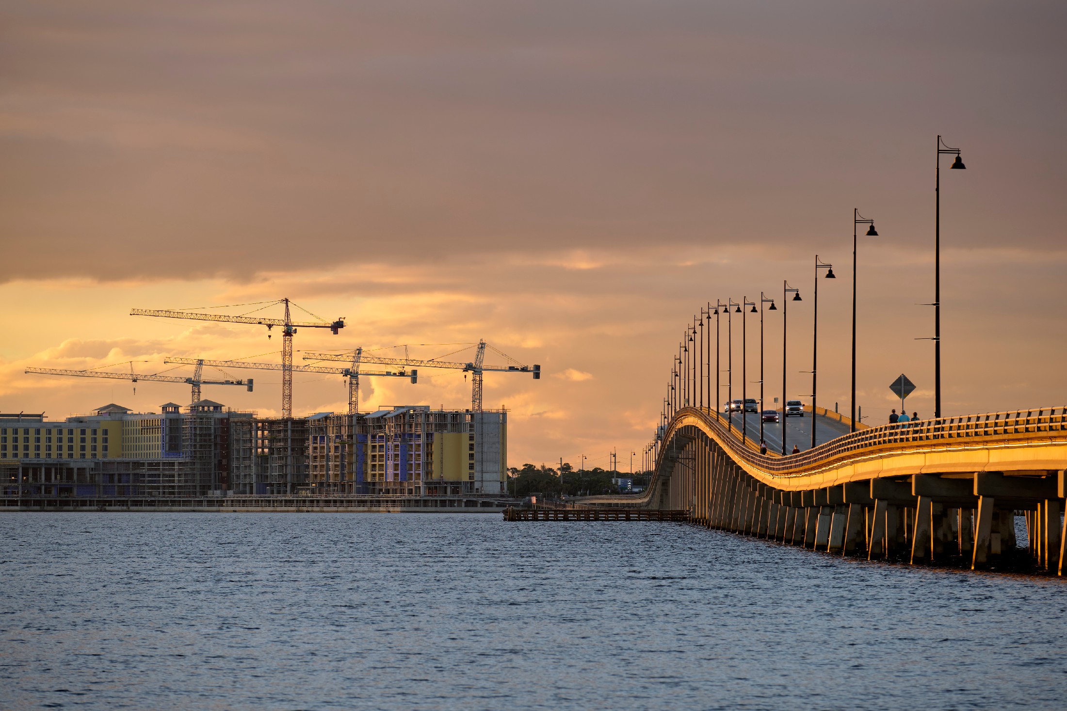 Tower Lifting Cranes At High Residential Apartment Buildings Construction Site. Real Estate Development